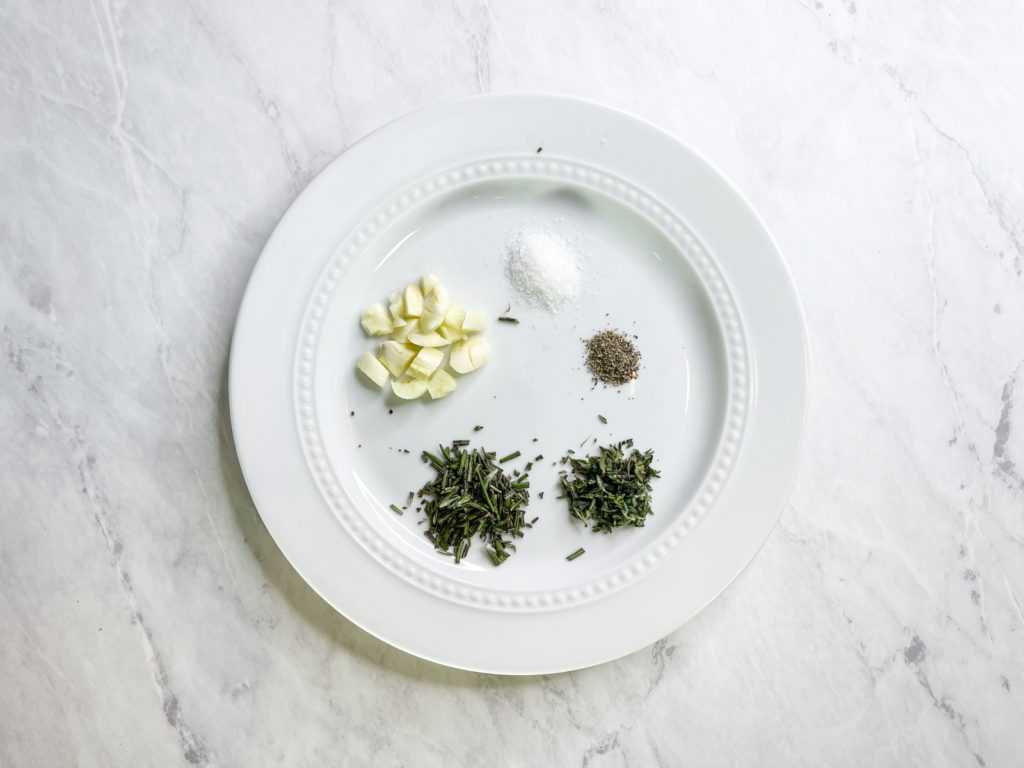 Herbs and seasonings needed to make the garlic herbed aioli recipe are garlic cloves, rosemary, thyme, salt and pepper.
