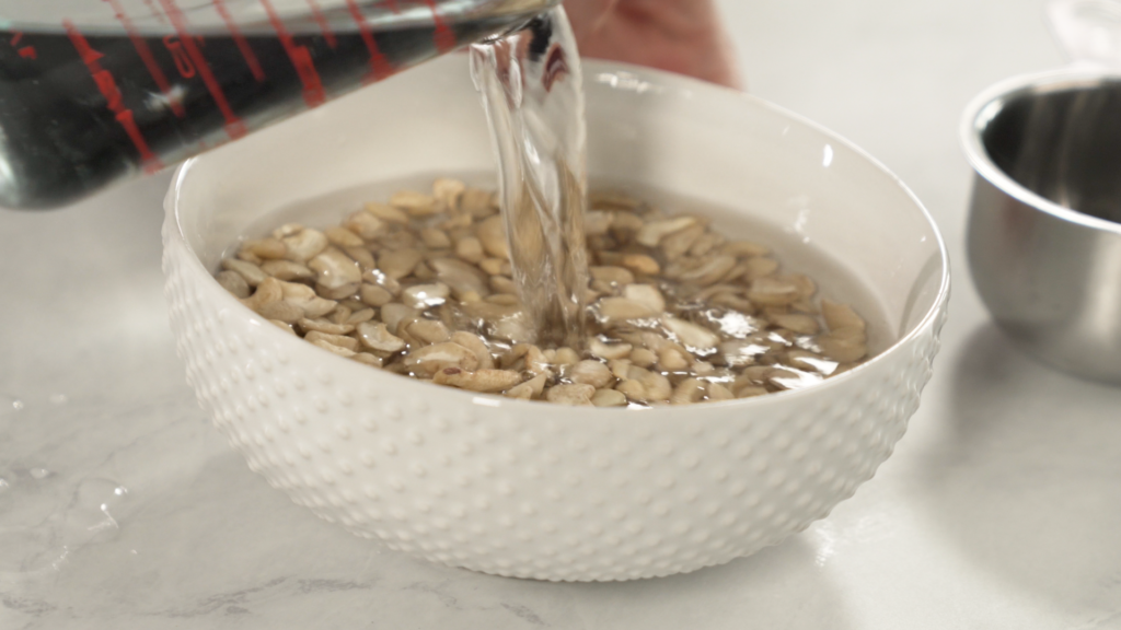 To make cashew milk, start by soaking the cashews in water for up to 2-3 hours.